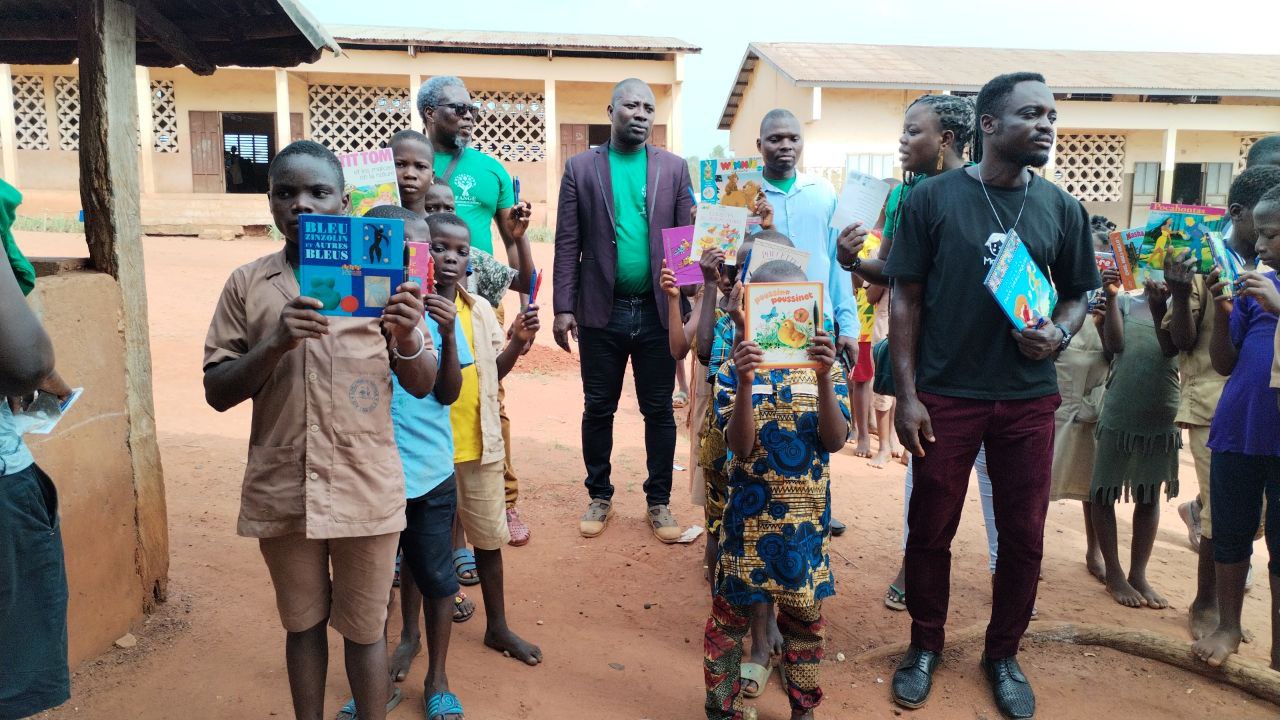 Distribution de livres scolaires à des élèves dans la cour d'école